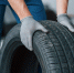 One more improvement and job will be done. Mechanic holding a tire at the repair garage. Replacement of winter and summer tires. - Iskitim-Gazeta.Ru